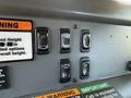 Control panel of a 2004 American LaFrance Eagle featuring several switches including a siren and brakes with noticeable wear on the switch surfaces