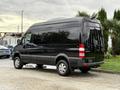 A black 2017 Mercedes-Benz Sprinter van parked with a high roof and large rear windows