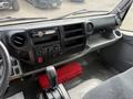 Interior view of a 2018 Hino 195 featuring a dashboard with controls a radio and a gear shift with a red toolbox visible on the passenger side