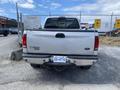 A 2007 Ford F-350 SD truck with a white exterior and a visible rear license plate parked in a lot