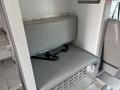 Interior view of a 1994 GMC Vandura 3500 showing a gray bench seat with a seatbelt and metal flooring beneath