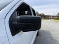 Close-up of the side mirror on a 2021 Ford F-150 showcasing a sleek black design and integrated features
