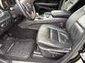 A 2019 Jeep Grand Cherokee interior featuring black leather seats a steering wheel with controls and a center console with gear shifter and cup holders