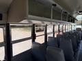Interior view of a 2009 International 3000 CE school bus with rows of gray seats and large windows providing natural light