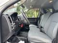 Interior view of a 2013 RAM 1500 featuring gray fabric seats a steering wheel a gear shift and dashboard elements
