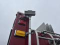 A red fire truck with a tall ladder and various light fixtures including red and yellow lights on the rear panel