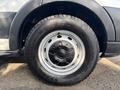 A close-up of a wheel from a 2016 Ford Transit 150 showing a silver rim with a black tire and a tread pattern designed for traction