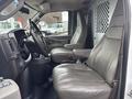 Interior of a 2022 GMC Savana showing two leather seats with armrests and a central console between them