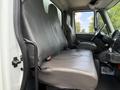 The interior of a 2014 International TerraStar featuring two large gray seats with a simple design and seatbelt attachments