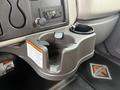 A gray cup holder with a compartment and a drink holder on the side, installed in the interior of a 2008 International 4300 truck