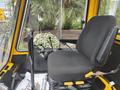 A black driver's seat and control panel of a 2004 Bombardier SW48 with joysticks levers and buttons for operation