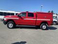 A red 2015 RAM 2500 truck with a utility bed and reflective stripes on the side