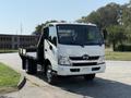 A 2012 Hino 155 white box truck with a flatbed and front cabin visible from an angle