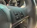 Close-up of the steering wheel controls featuring three buttons for navigation or settings in a 2004 BMW 6-Series