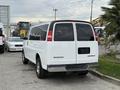A white 2004 Chevrolet Express van parked in a lot with its rear view visible showing the tail lights and chrome bumper