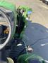 A green 2008 John Deere 3320 300X tractor with a steering wheel and control levers visible in the foreground