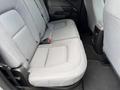 A 2018 Chevrolet Colorado with gray fabric upholstery in the rear seating area featuring two individual seats and a middle armrest