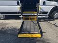 A lowered accessibility ramp extends from a 2020 RAM ProMaster 3500 with a textured surface and yellow edges designed for wheelchair access