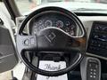 The interior view of a 2012 International 7400 featuring a black steering wheel with controls and a dashboard displaying multiple gauges and a control panel