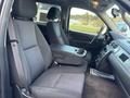 Interior view of a 2011 Chevrolet Avalanche showing front seats and center console with cup holders