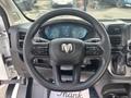 The interior view of a 2023 RAM Promaster 3500 featuring a steering wheel with buttons and a dashboard displaying two circular gauges and information panel
