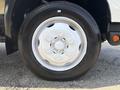 Close-up of the wheel of a 2018 Hino 195 featuring a silver rim and a large black tire with tire size details visible on the sidewall