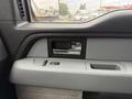 Interior door handle and armrest of a 2014 Ford F-150 with a window control switch and storage pocket visible
