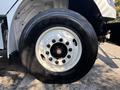 Close-up of the large wheel and tire of a 2019 Freightliner M2 106 showing a white rim with multiple lug nuts and a black tire tread
