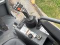 Control panel of a 2014 Wacker Neuson WL34 featuring a joystick, buttons, and various dials for operation