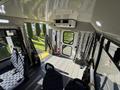 Interior view of a 2015 Ford Econoline showing the seating area with two seats and various safety features mounted on the walls