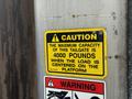 A yellow caution sign displaying information about the maximum capacity of a tailgate indicating a load limit of 4000 pounds when centered on the platform