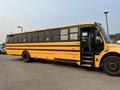 A yellow 2007 Freightliner B2 school bus with black stripes and multiple windows along the side