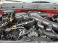 A close-up view of the engine compartment of a 2013 Ford F-550 showing various components including hoses wires and the alternator
