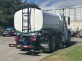 A 2022 Freightliner M2 106 truck with a tank attached to the back featuring a ladder and a hose connected to the tank