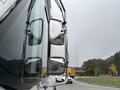 A 2012 Ford E-450 Super Duty with side mirrors reflecting the surroundings