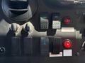 Control panel with switches and indicators for a 2012 Ford Econoline including buttons for cargo fans seatbelt and a red light