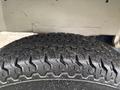 Close-up of a textured tire tread of a 2008 Suzuki Carry showing rugged patterns and dirt accumulation on the surface