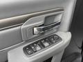 Close-up of the interior door handle and control panel of a 2018 RAM 1500 featuring window controls and door locking mechanisms