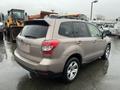 2016 Subaru Forester in a light brown color parked with a visible rear view and alloy wheels