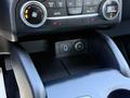Interior view of a 2020 Ford Escape showing the center console with climate control knobs and a 12V power outlet
