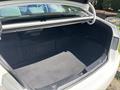A 2014 Hyundai Sonata with an open trunk showcasing a spacious cargo area and a flat trunk floor