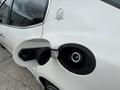 A close-up of the fuel cap and fill area of a white 2016 Maserati Ghibli featuring a sleek design and the Maserati logo