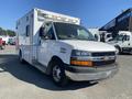 A 2011 Chevrolet Express van in white with a black front grille and two headlights mounted above the windshield