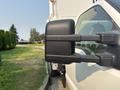 A 2009 Ford F-550 truck with a black side mirror prominently displayed in the foreground