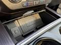A storage compartment in the center console of a 2021 Ford F-350 SD featuring a wireless charging pad and USB ports