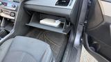 A 2018 Hyundai Sonata interior showing a spacious glove compartment with items inside and a black cloth seat in the foreground
