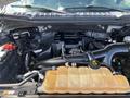 Engine compartment of a 2015 Ford F-150 showcasing the engine with various components including hoses and a coolant reservoir