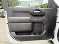 A close-up of the driver's side door interior of a 2022 GMC Sierra 1500 showing the armrest handle and controls
