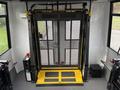 Interior view of a 2021 Ford Transit-350 with a foldable wheelchair lift featuring a mesh enclosure and yellow platform