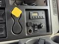The dashboard controls of a 2011 International WorkStar featuring buttons for engine intake and winter mode a circular ignition switch and a yellow retractable object holder